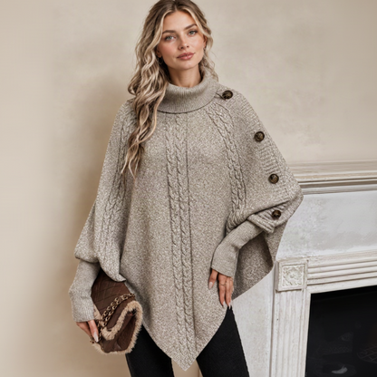 Pull poncho beige avec le décor de la cheminée
